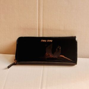 Miu Miu Black Patent Leather Zippy Wallet w pink leather lining + bow detail.